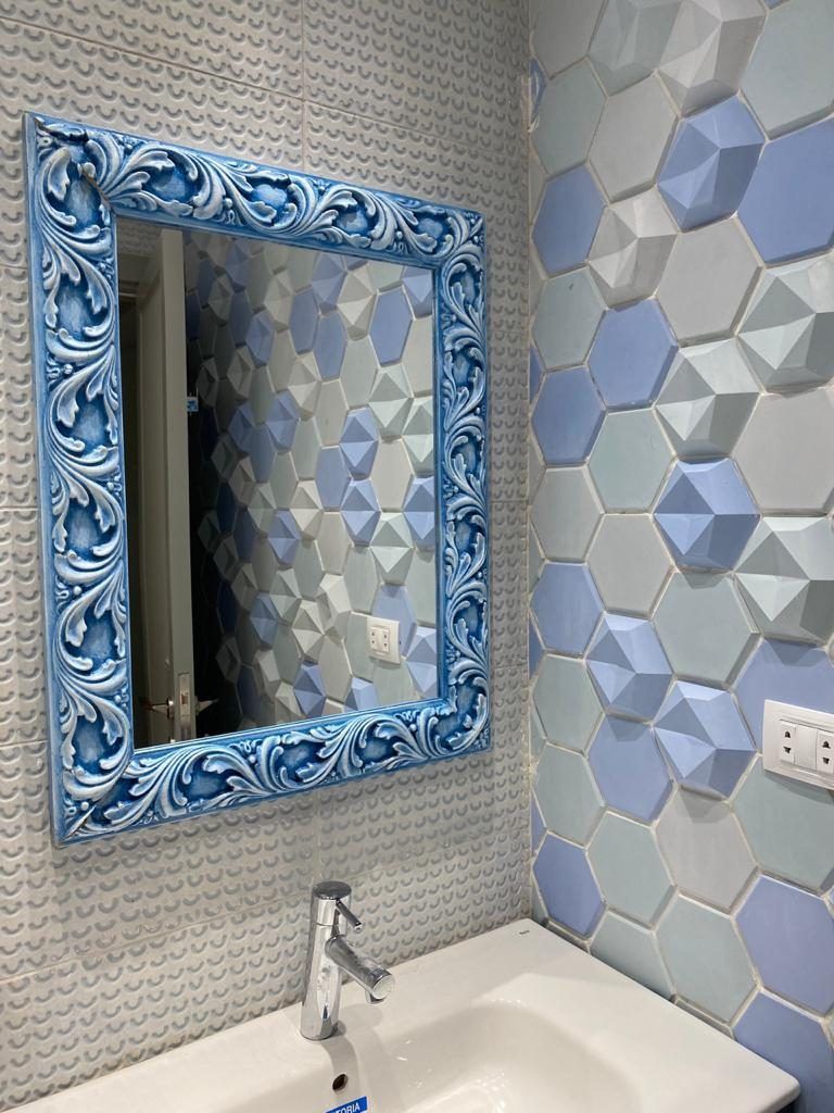Bathroom with 3D hexagon wall tiles and an ornate blue framed mirror