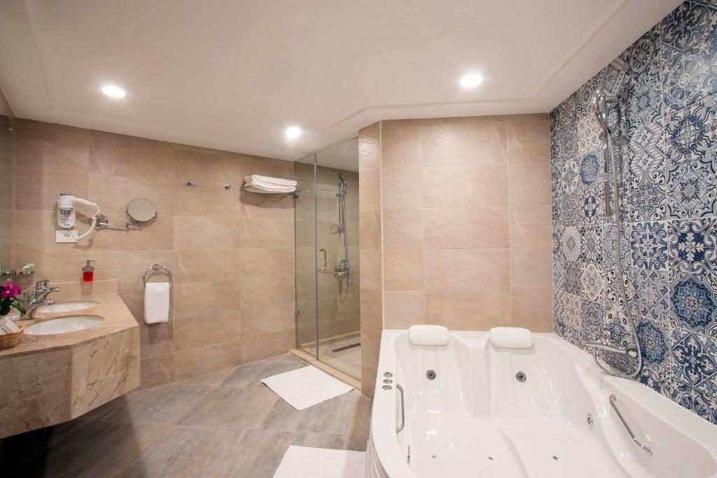 Bathroom with glass shower, jacuzzi tub and patterned tile feature wall