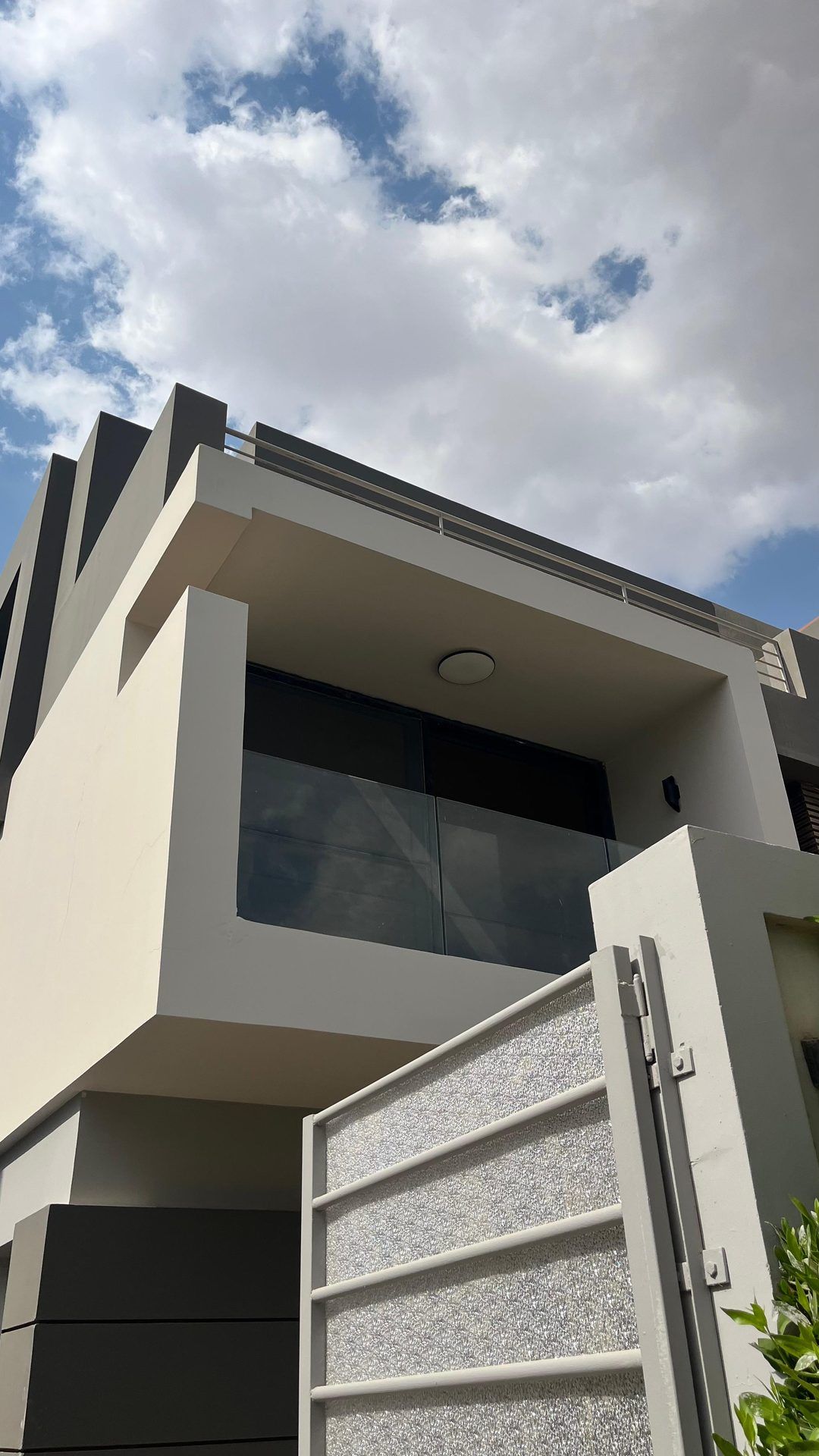 Cantilevered balcony and gate under a blue sky