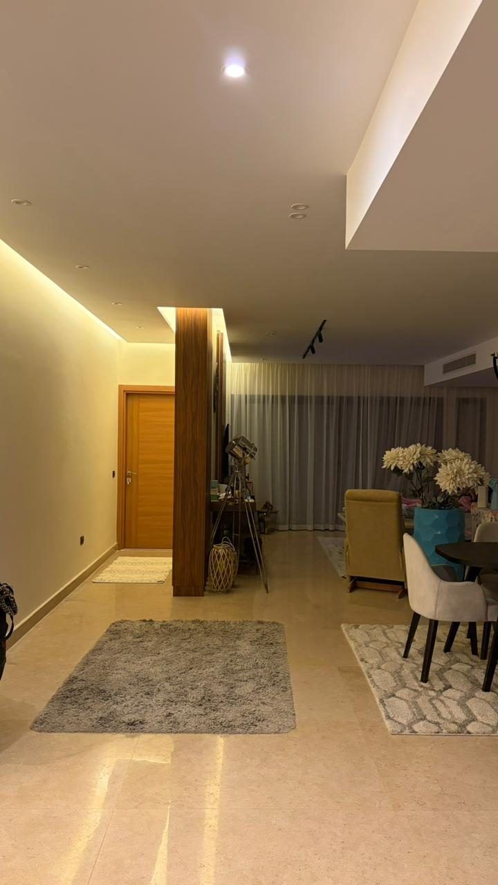 Entrance corridor with marble floor, walnut column and indirect ceiling lighting