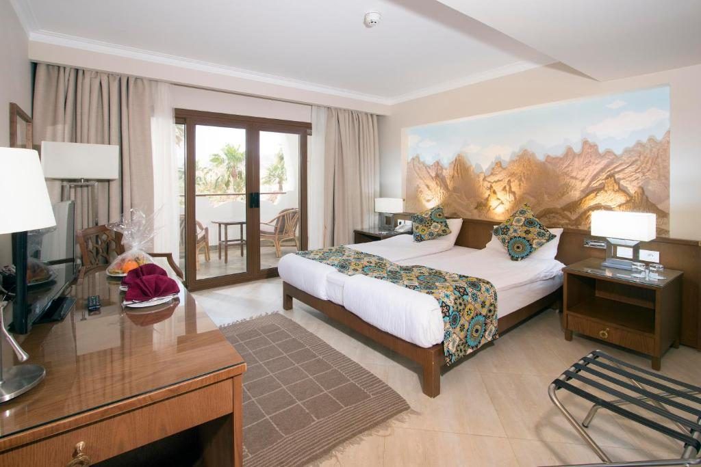 Guest room with sea-view balcony and illustrated mountain headboard wall