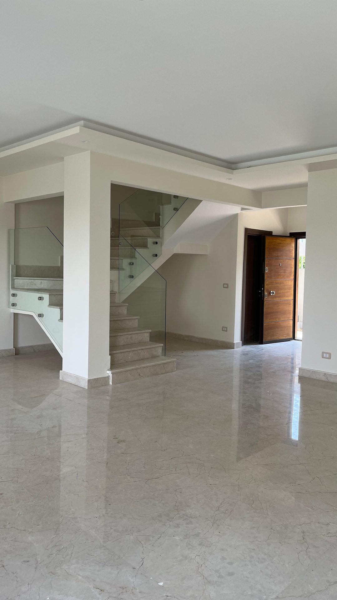 Bright ground floor with marble floor and glass-balustrade staircase