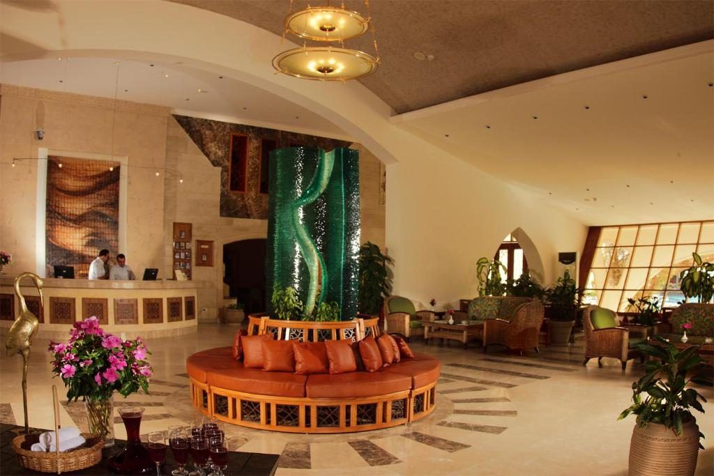 Hotel lobby with domed ceiling, green glass feature column and circular banquette