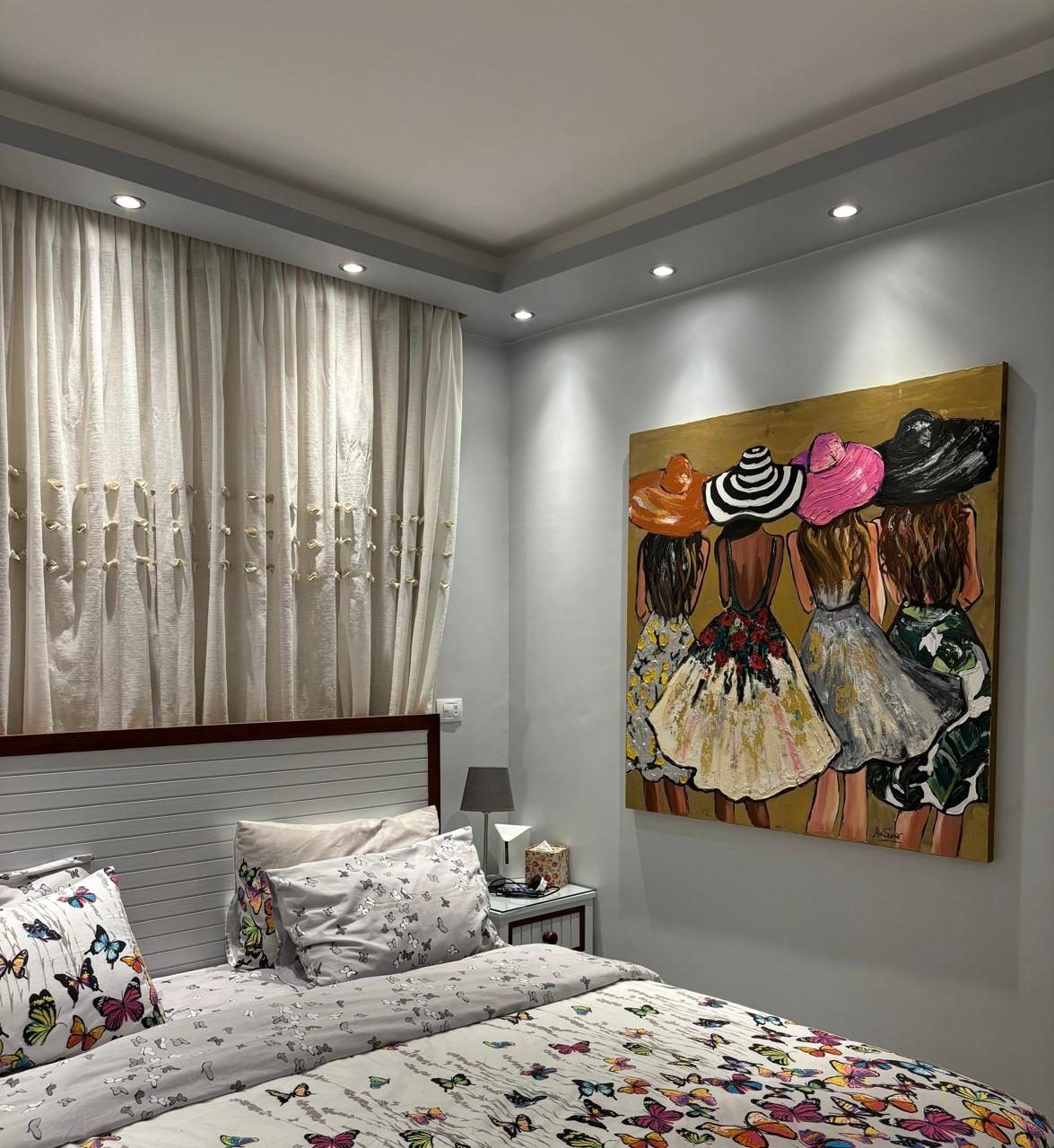 Bedroom with cove-lit ceiling, sheer curtains and a large painted canvas