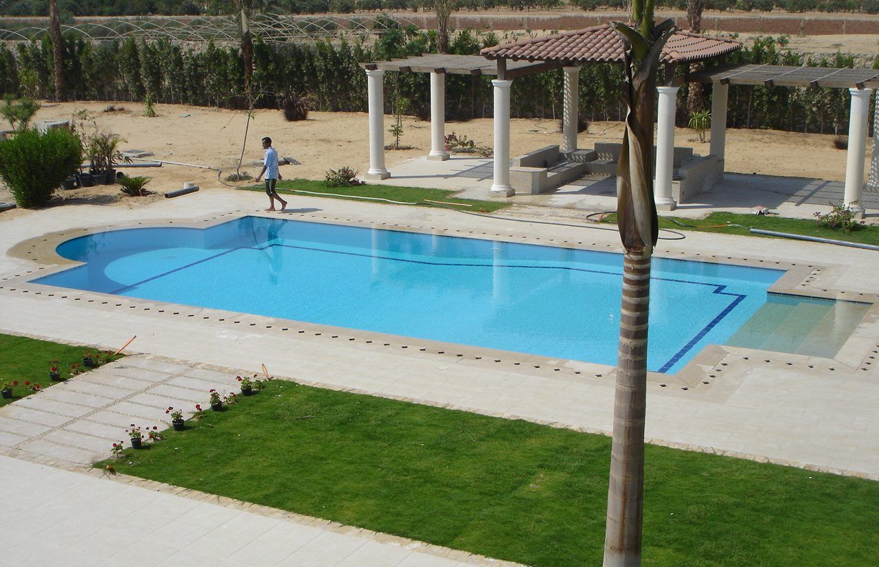 Pool and lawn with pergolas and palms