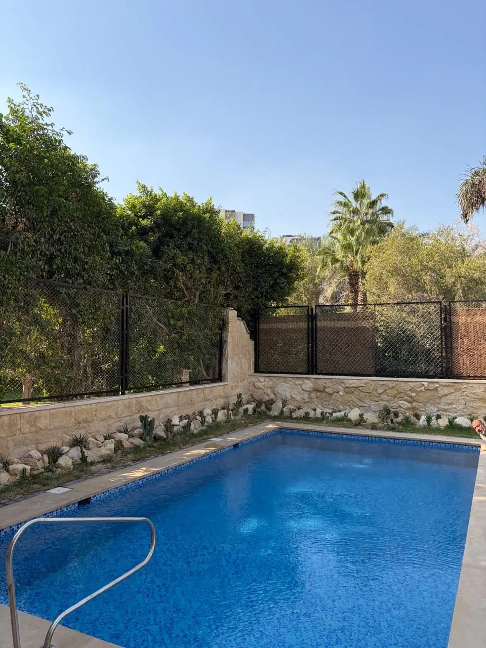 After: mosaic pool with stone-clad garden wall