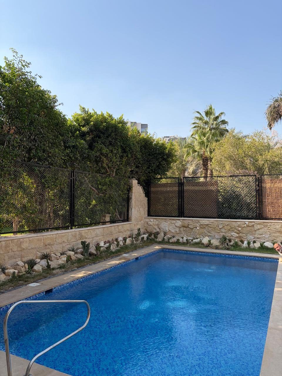 Mosaic pool with stone-clad garden wall