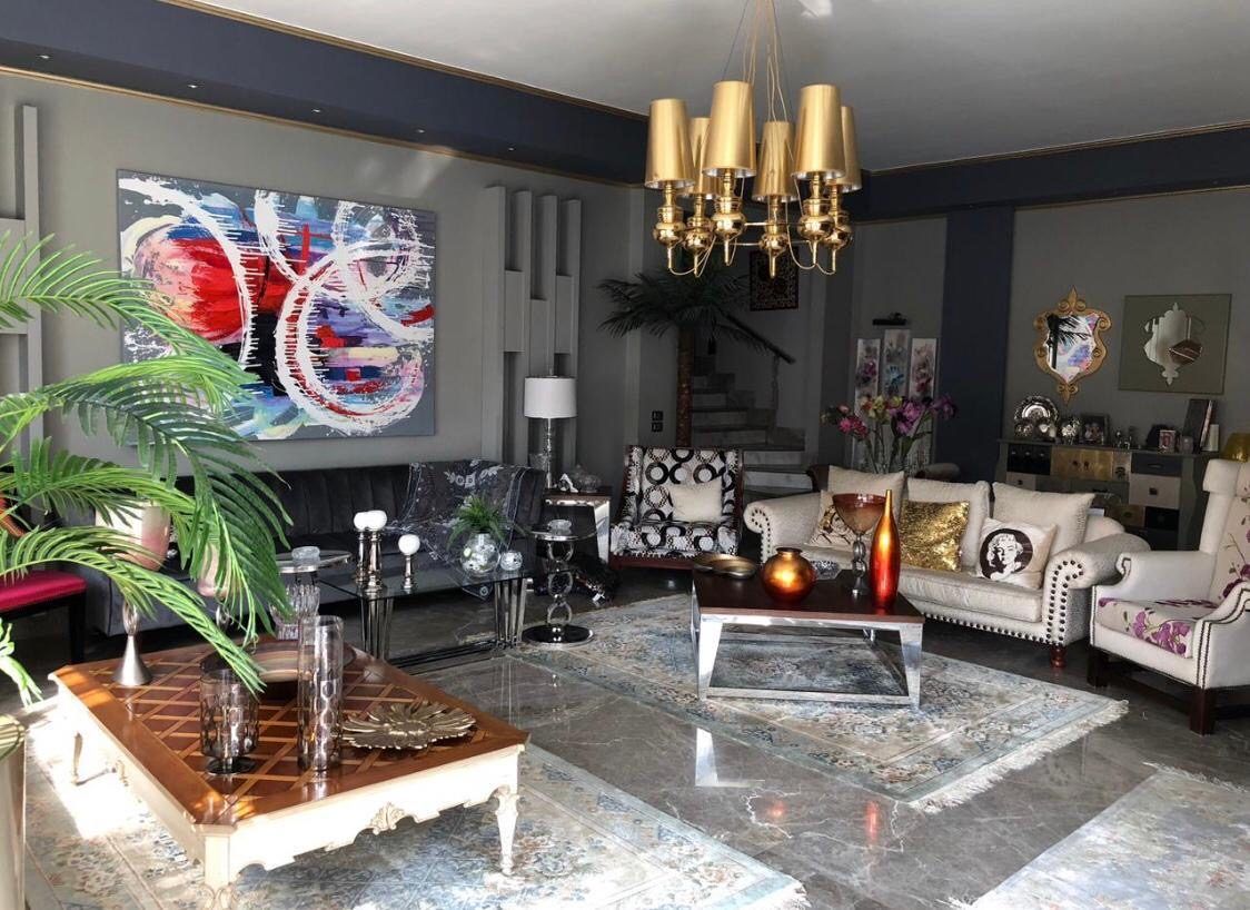 Reception with brass chandelier, tufted sofas and abstract wall art