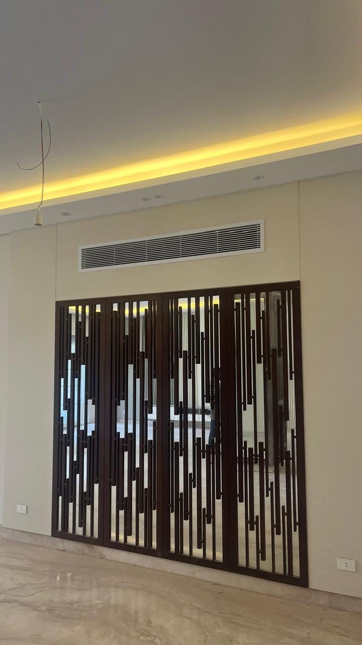 Laser-cut timber screen under a cove-lit ceiling