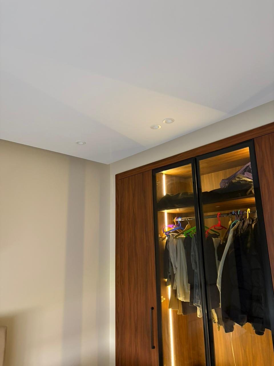 Walnut wardrobe with lit glass doors